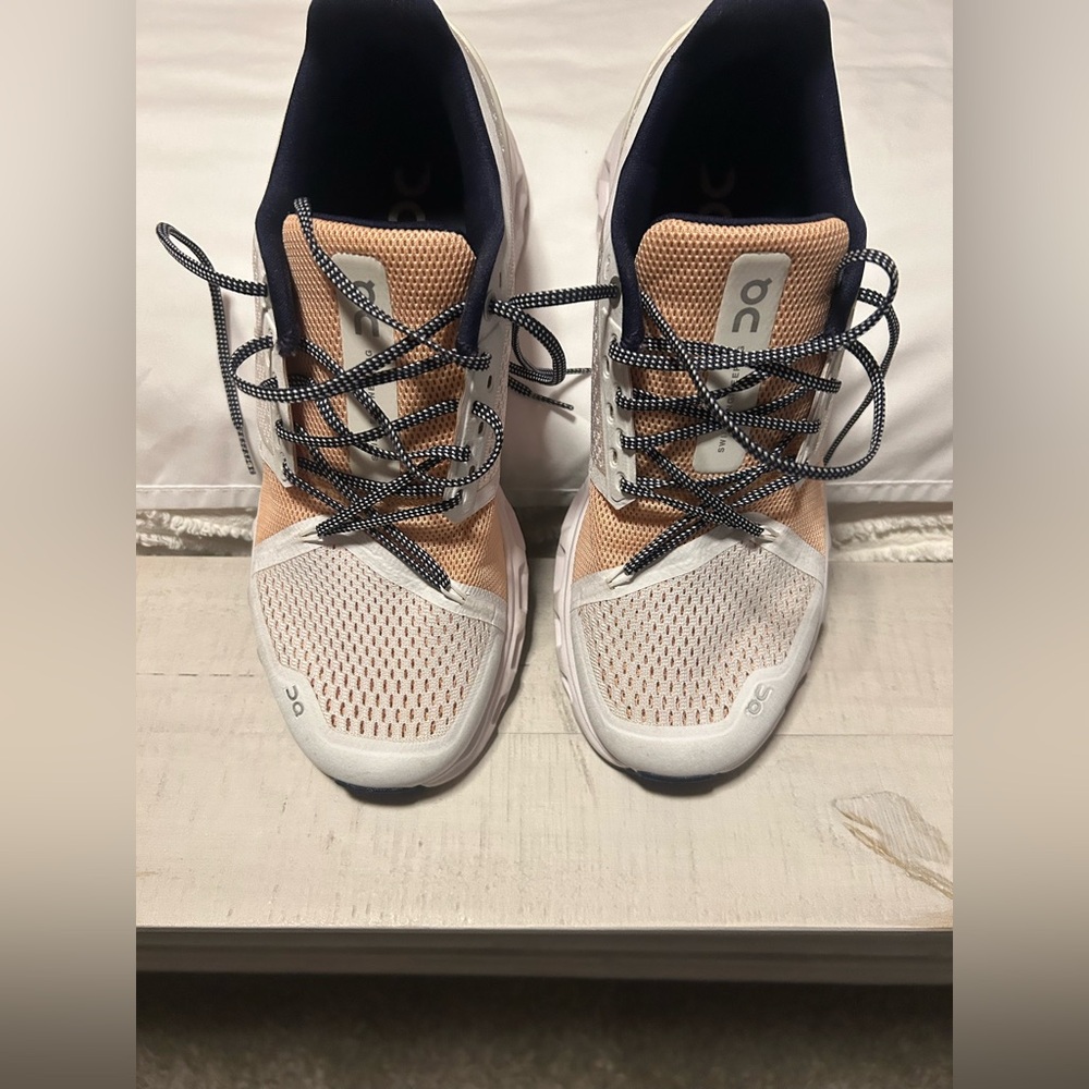 On Cloud Running Shoes in Peach,  White and blue.